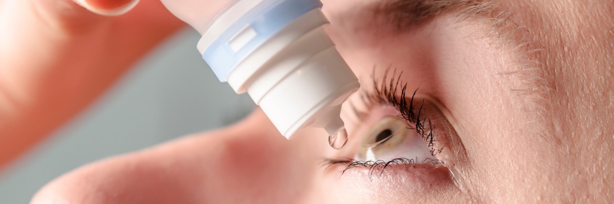 Person putting eye drops in (close-up)