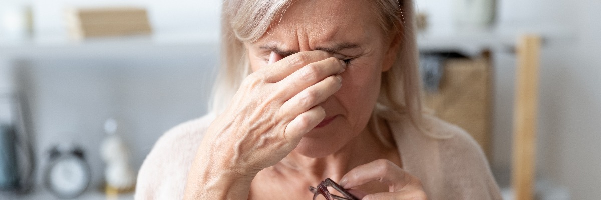Woman holds her eyes in irritation