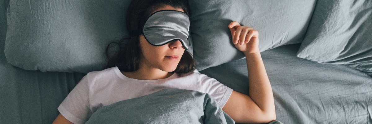 Woman wears facemask in bed