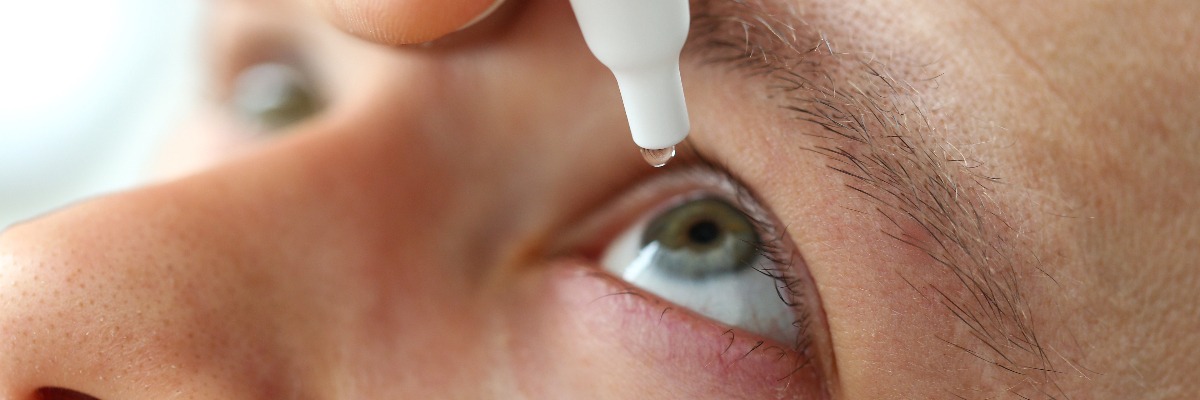 Close up of man putting eye drops into his eye