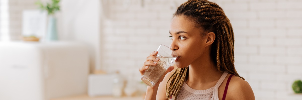 woman with dry eye drinking a glass of water